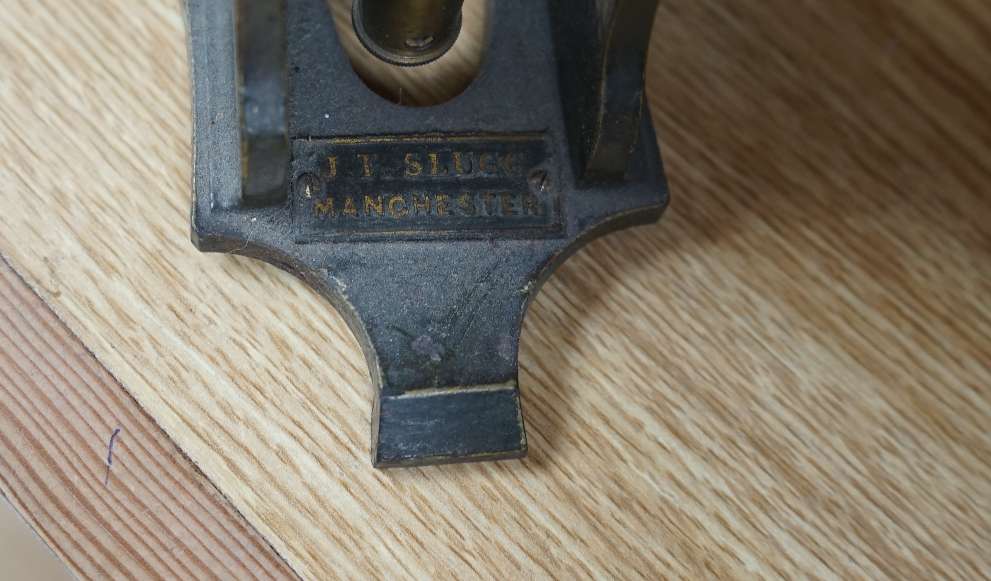 A Victorian brass microscope, J T Slugg, Manchester, in original wooden case, with a small selection of slides. Condition - fair, untested